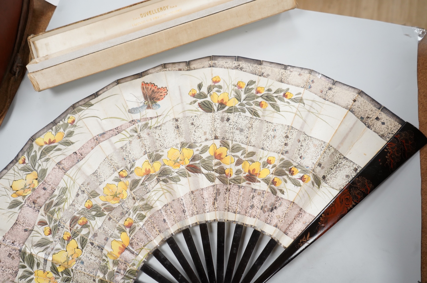 A gold mounted lace and hand painted fan and three others to include a lacquered example, one cased